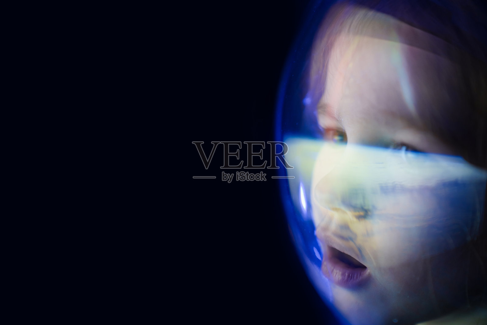 女孩梦想成为宇航员，飞上太空。反映了地球照片摄影图片