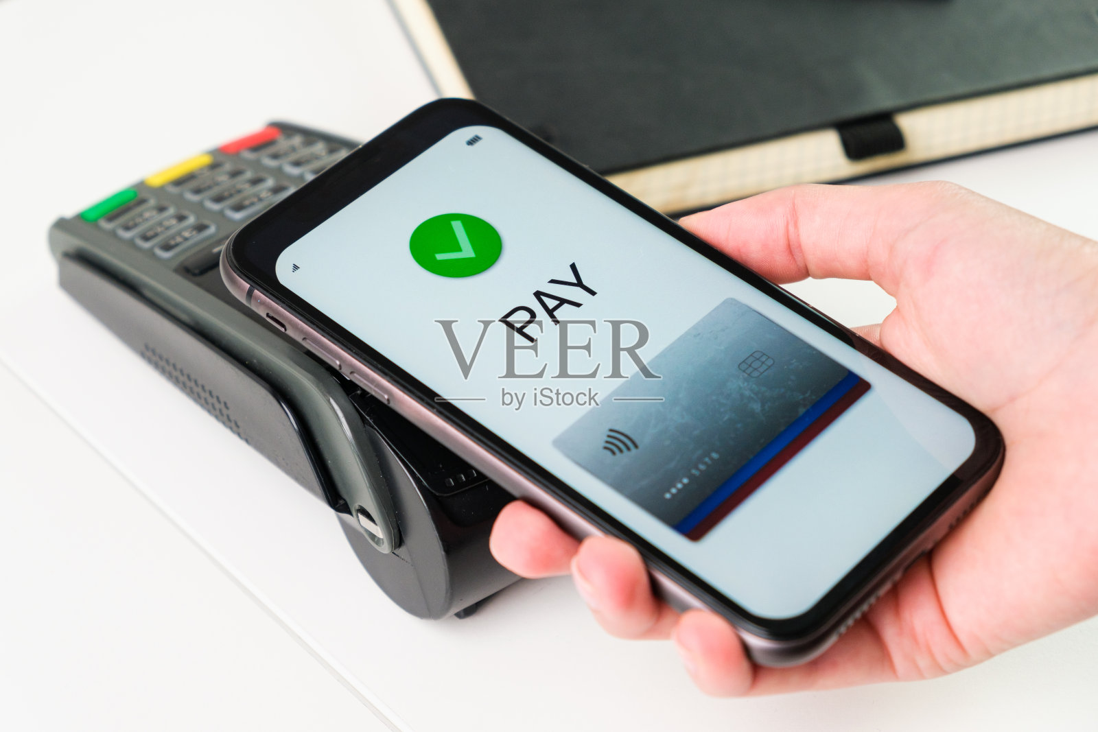 客户使用手机应用和POS机支付账单。在智能手机钱包照片摄影图片