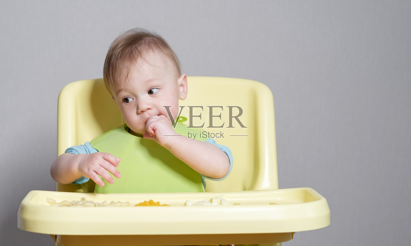 小孩子在灰色背景上吃东西照片摄影图片