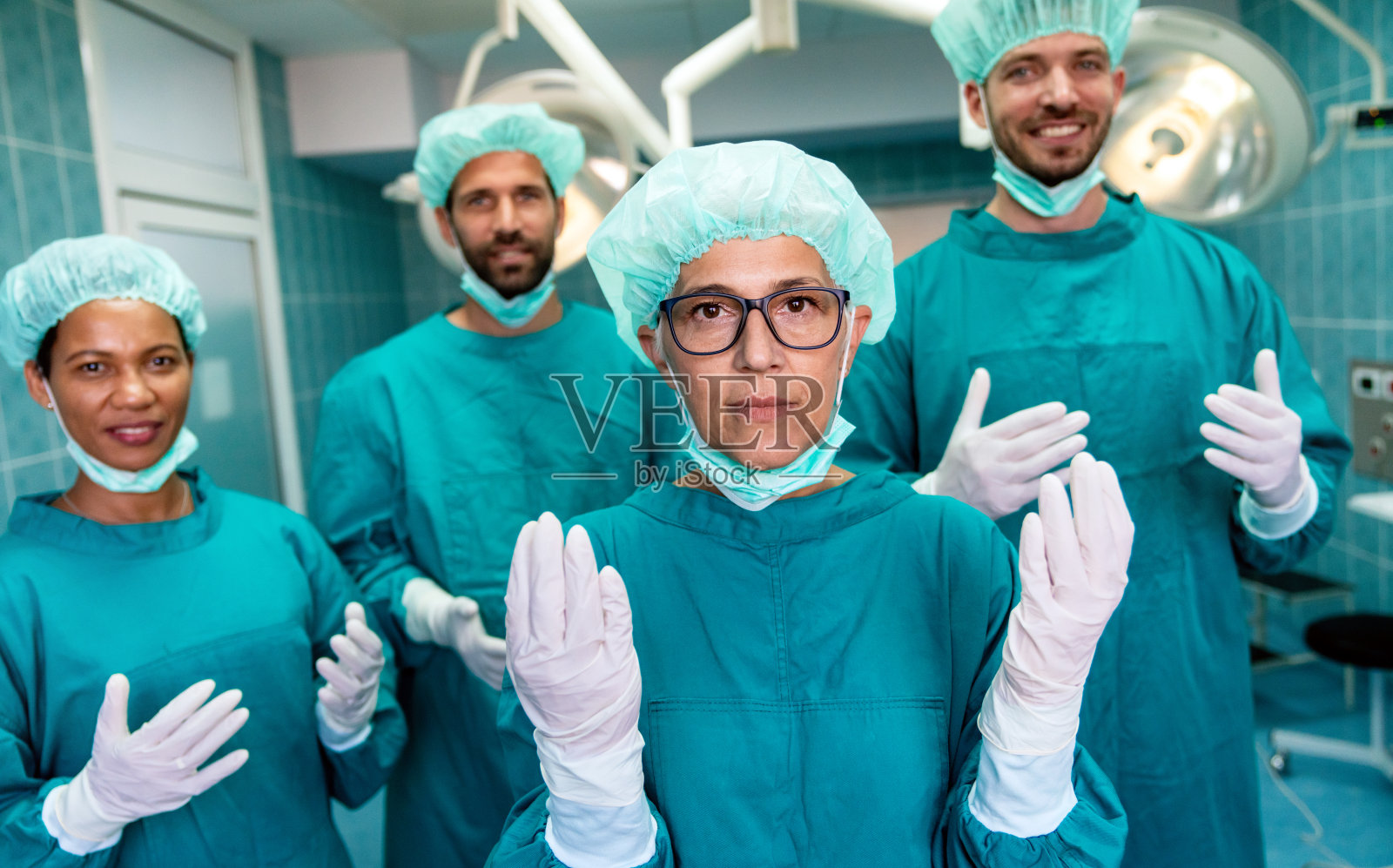 成功的外科医生站在手术室，准备工作的肖像照片摄影图片