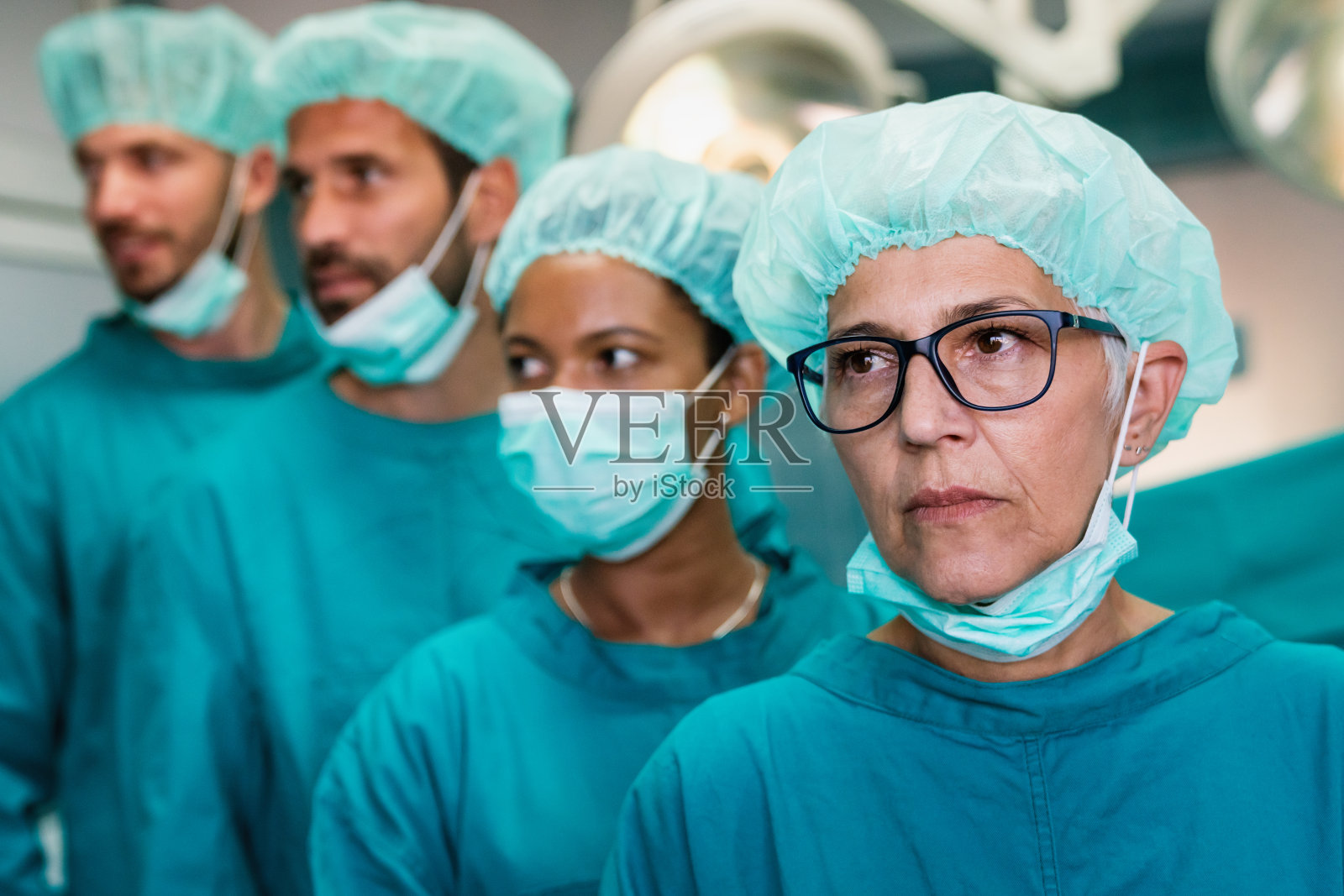 成功的外科医生团队站在手术室，准备为病人工作照片摄影图片