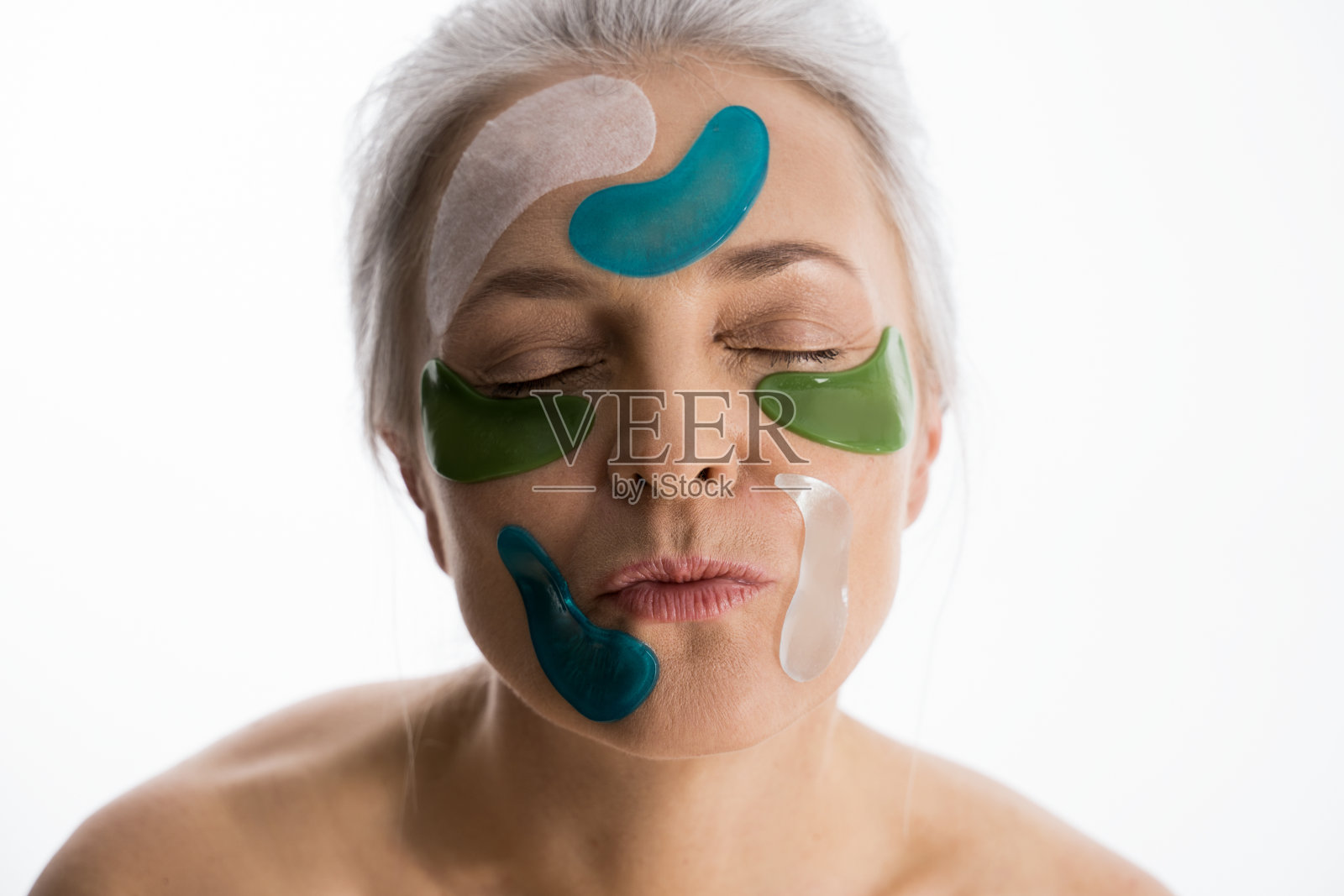 有完美皮肤的女人摆姿势，脸上有很多眼罩照片摄影图片