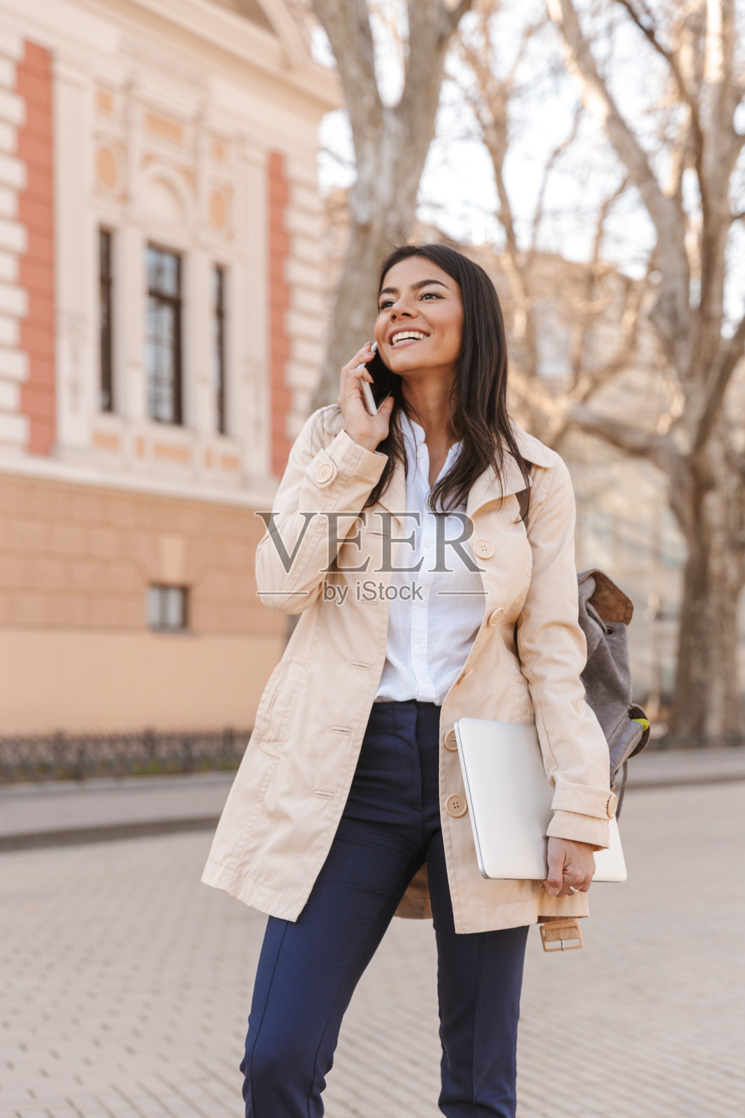 穿着秋天大衣的快活的年轻女子照片摄影图片