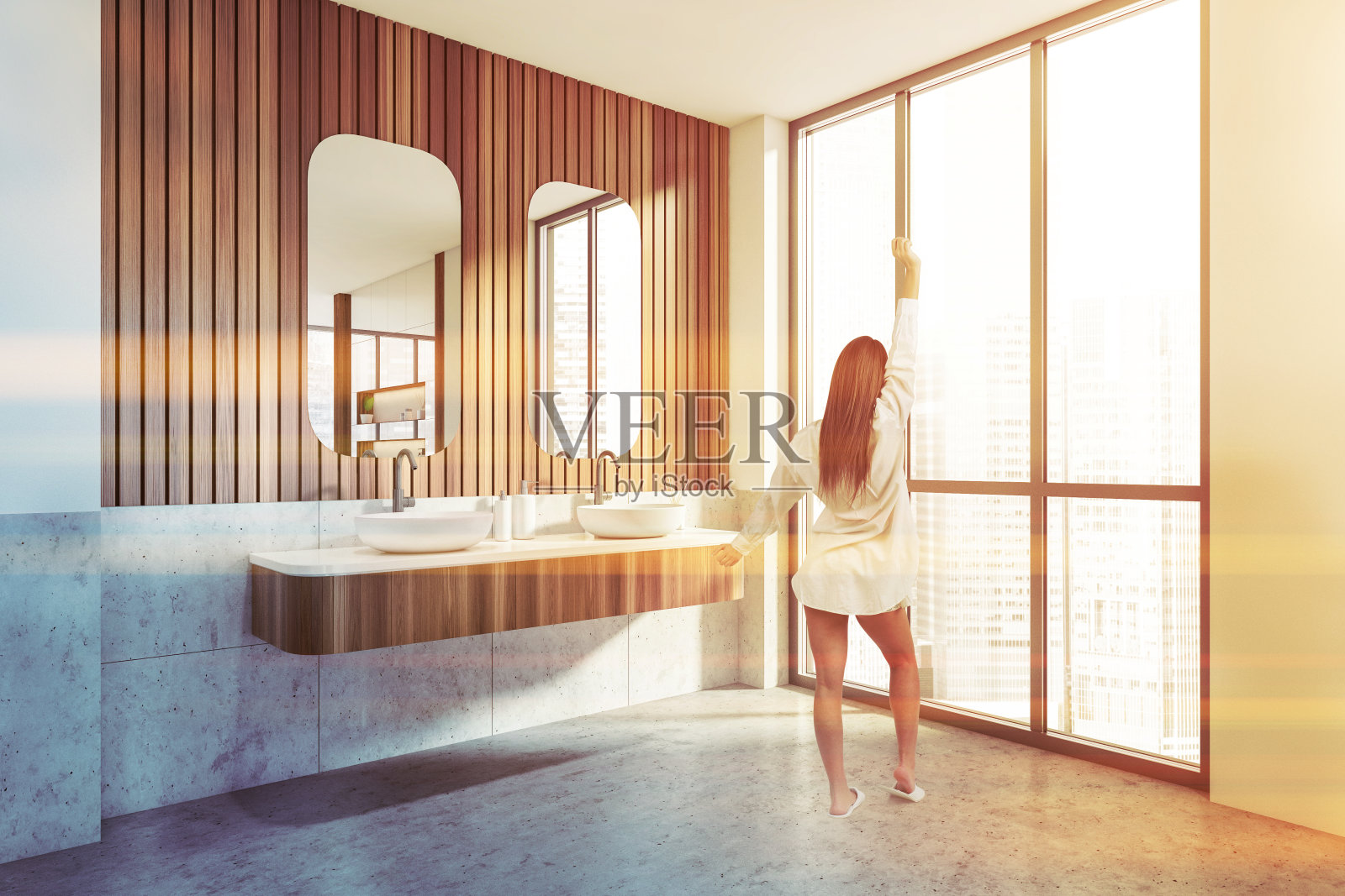 女人在浴室内部有两个水槽，窗户可以看到城市风景照片摄影图片