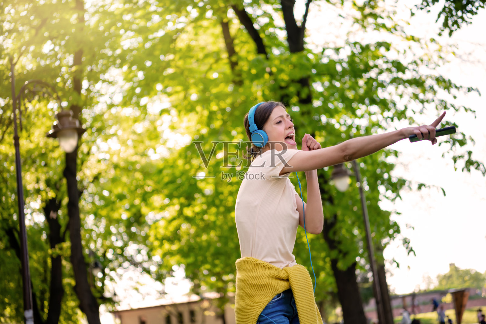 戴着耳机的女人在公园里跳舞照片摄影图片