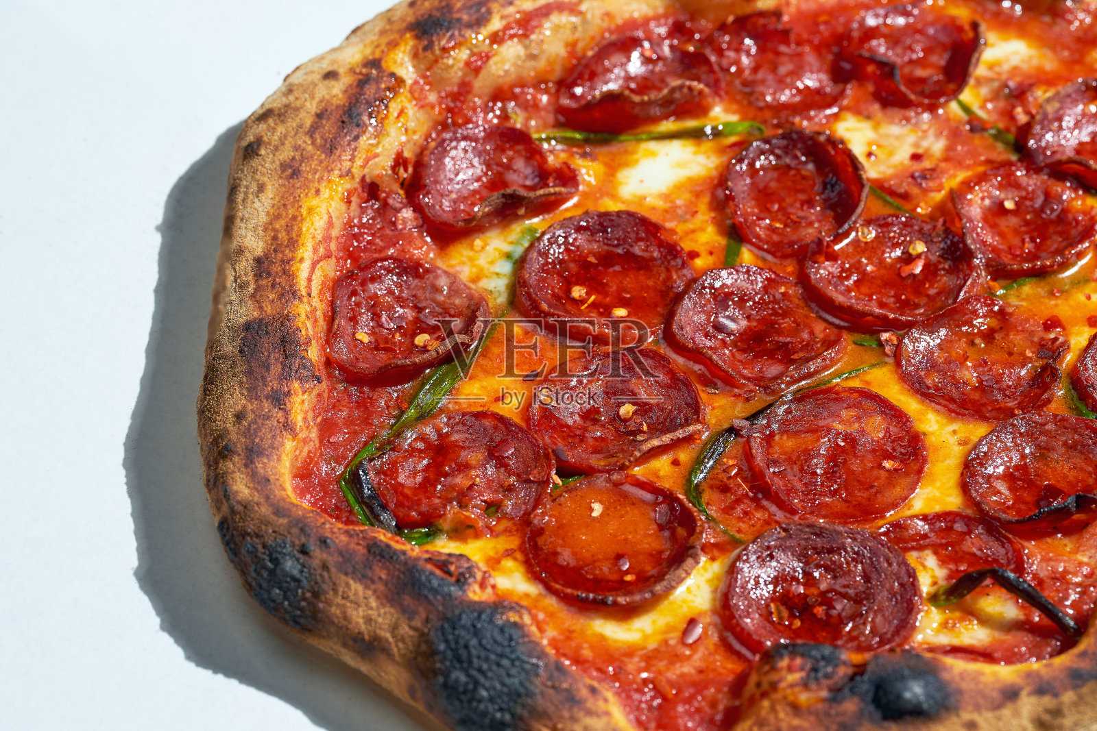 令人开胃的辣香肠披萨，配上番茄酱，意大利腊肠和墨西哥胡椒。脆皮。硬光。灰色的背景。照片摄影图片