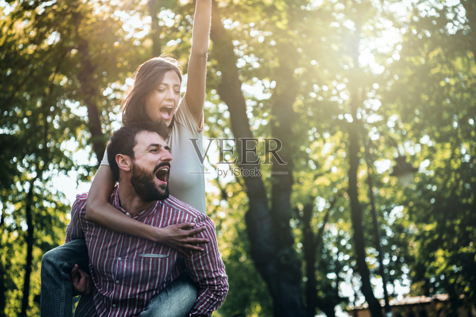 年轻夫妇在公园里玩得很开心。照片摄影图片