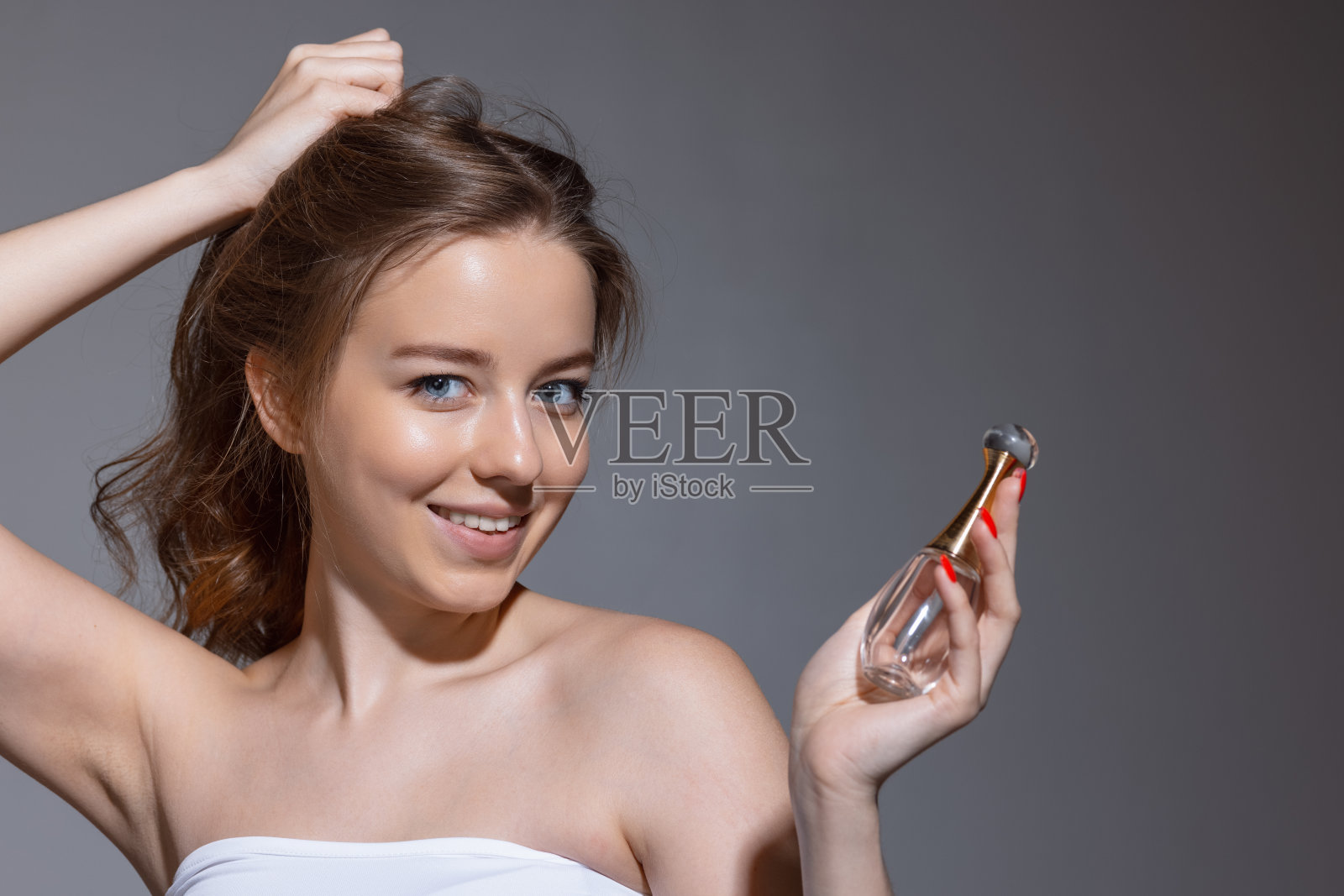 肖像年轻女性时装模特孤立在灰色工作室背景。漂亮的白人女人，皮肤保养得很好。照片摄影图片