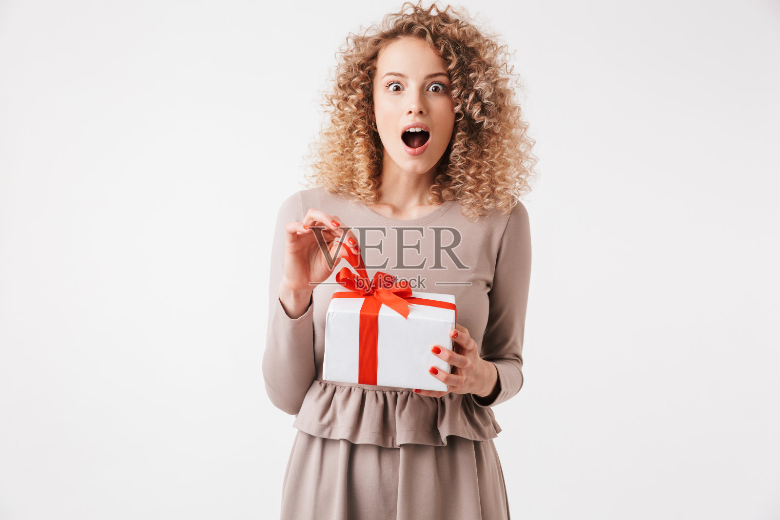 一个穿着衣服的兴奋的年轻卷发金发女孩的肖像照片摄影图片