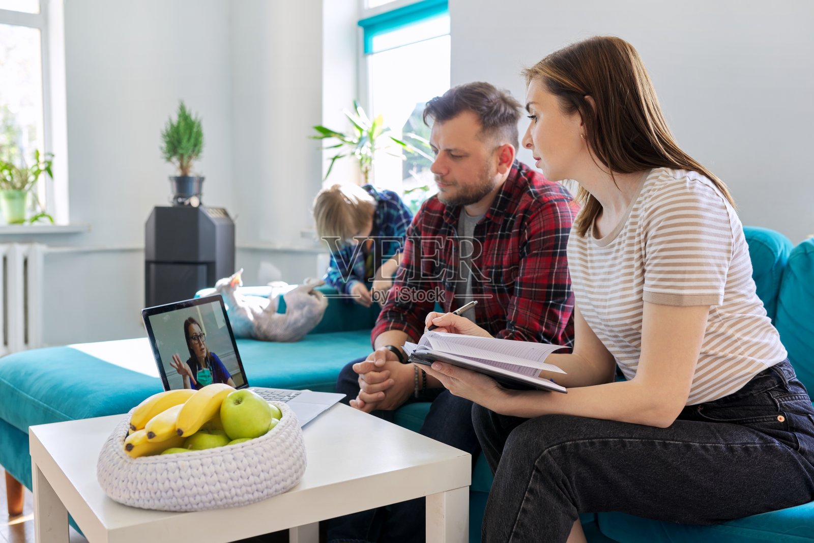 在线医疗咨询，家人坐在家里客厅的沙发上用笔记本电脑照片摄影图片