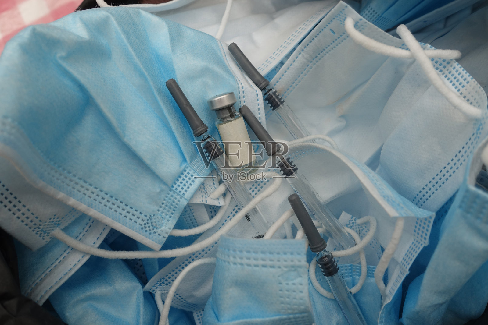 疫苗接种中心将医用口罩和使用过的注射器放入垃圾袋内照片摄影图片