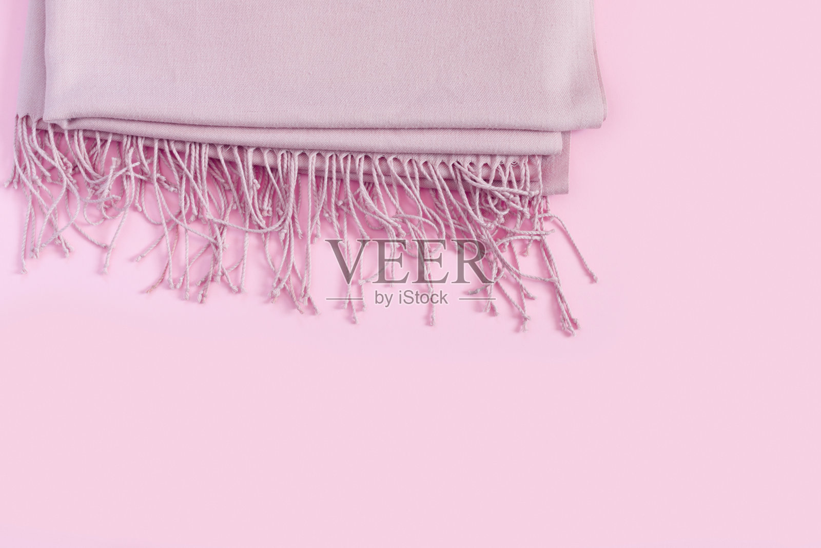 温暖美丽的羊毛围巾在粉红色的背景。照片摄影图片