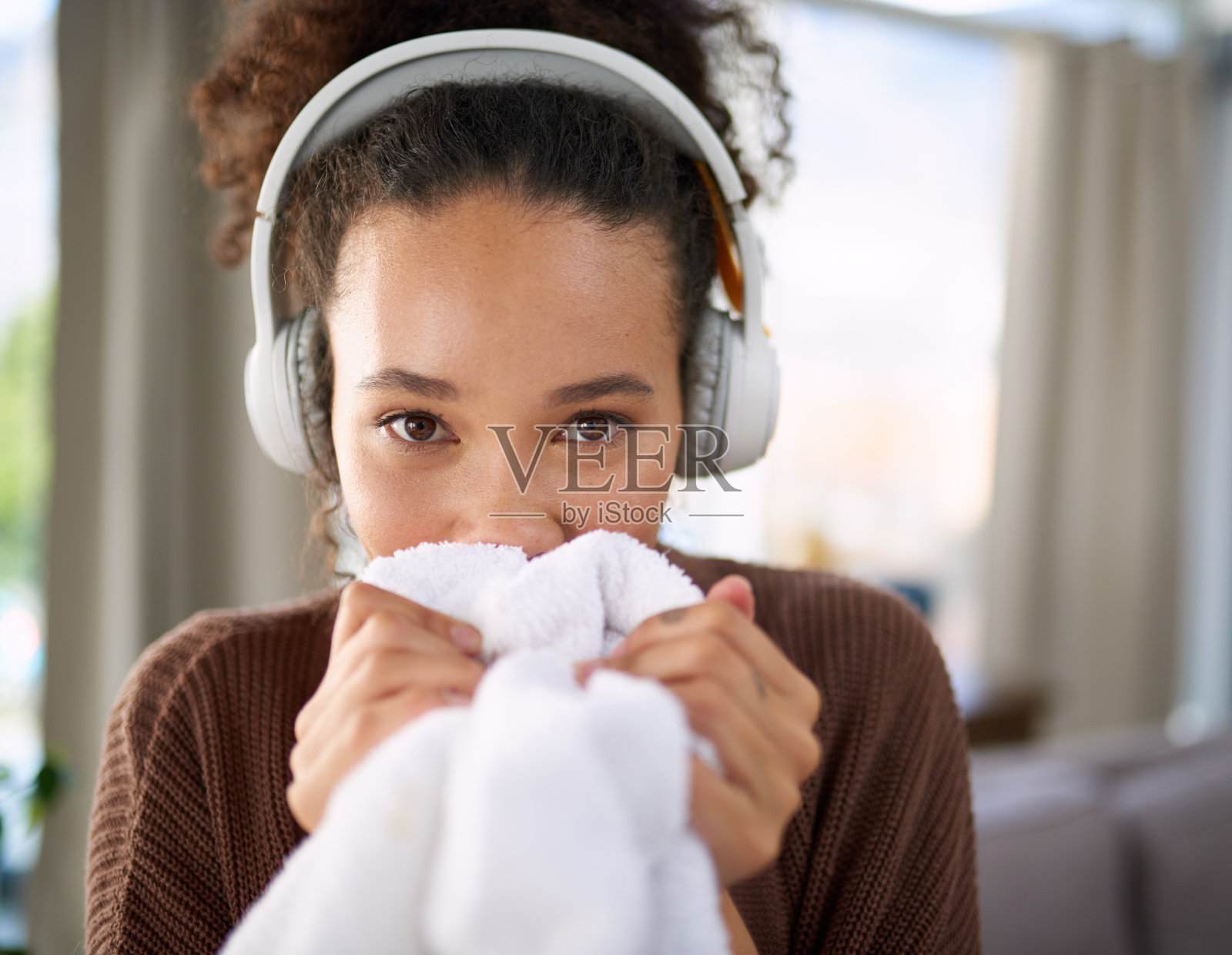 一个女人坐在家里闻刚洗过的衣服照片摄影图片
