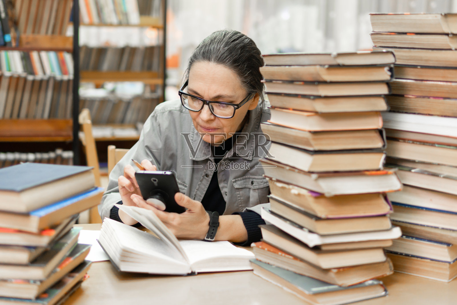 女人在图书馆的书架前。教育的概念照片摄影图片