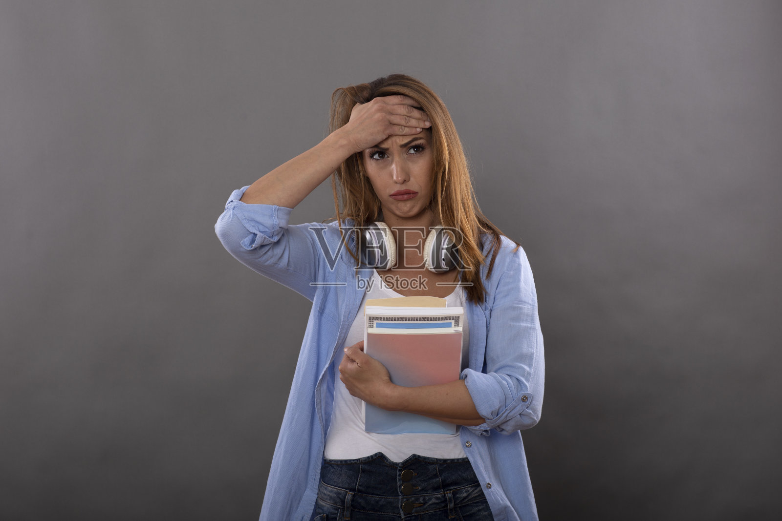 迷人的黑发学生女孩穿着休闲服装显示不满和失望的面部表情孤立在灰色的背景照片摄影图片