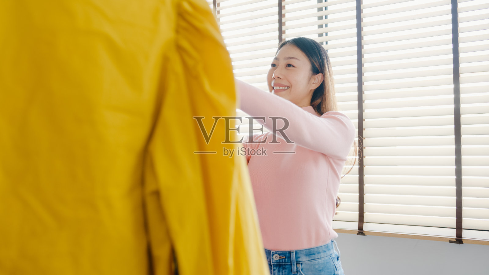 美丽迷人的年轻亚洲女士选择她的时尚服装在衣柜在房子或商店。照片摄影图片