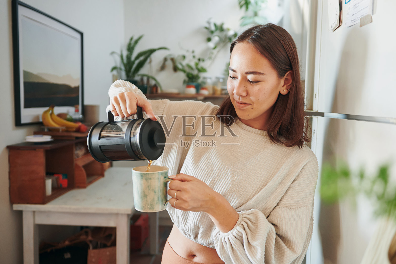 一个年轻女人给自己倒咖啡的照片照片摄影图片