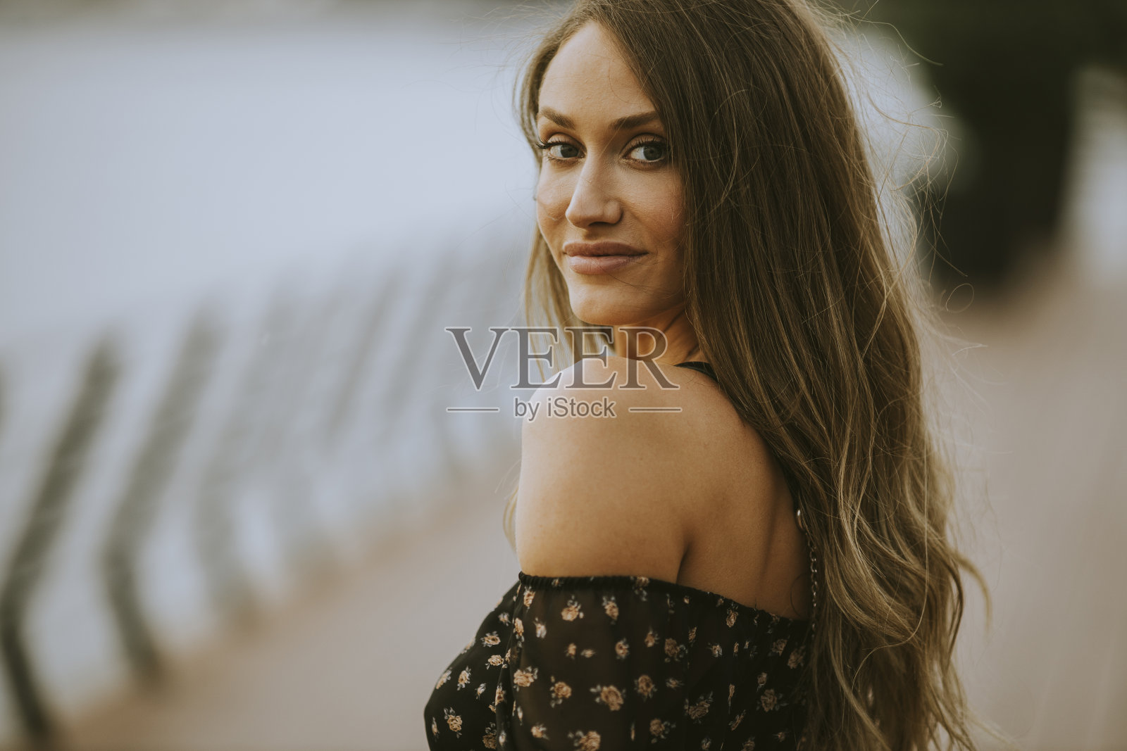 年轻的长发黑发女子走在河边照片摄影图片