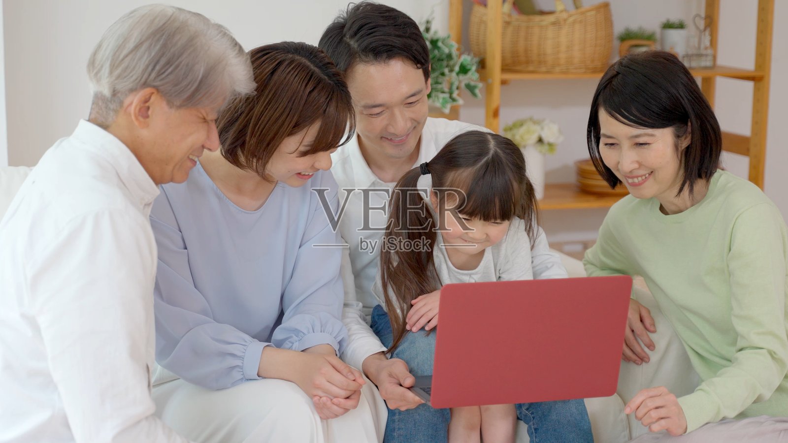 三代亚洲家庭在客厅里使用笔记本电脑照片摄影图片