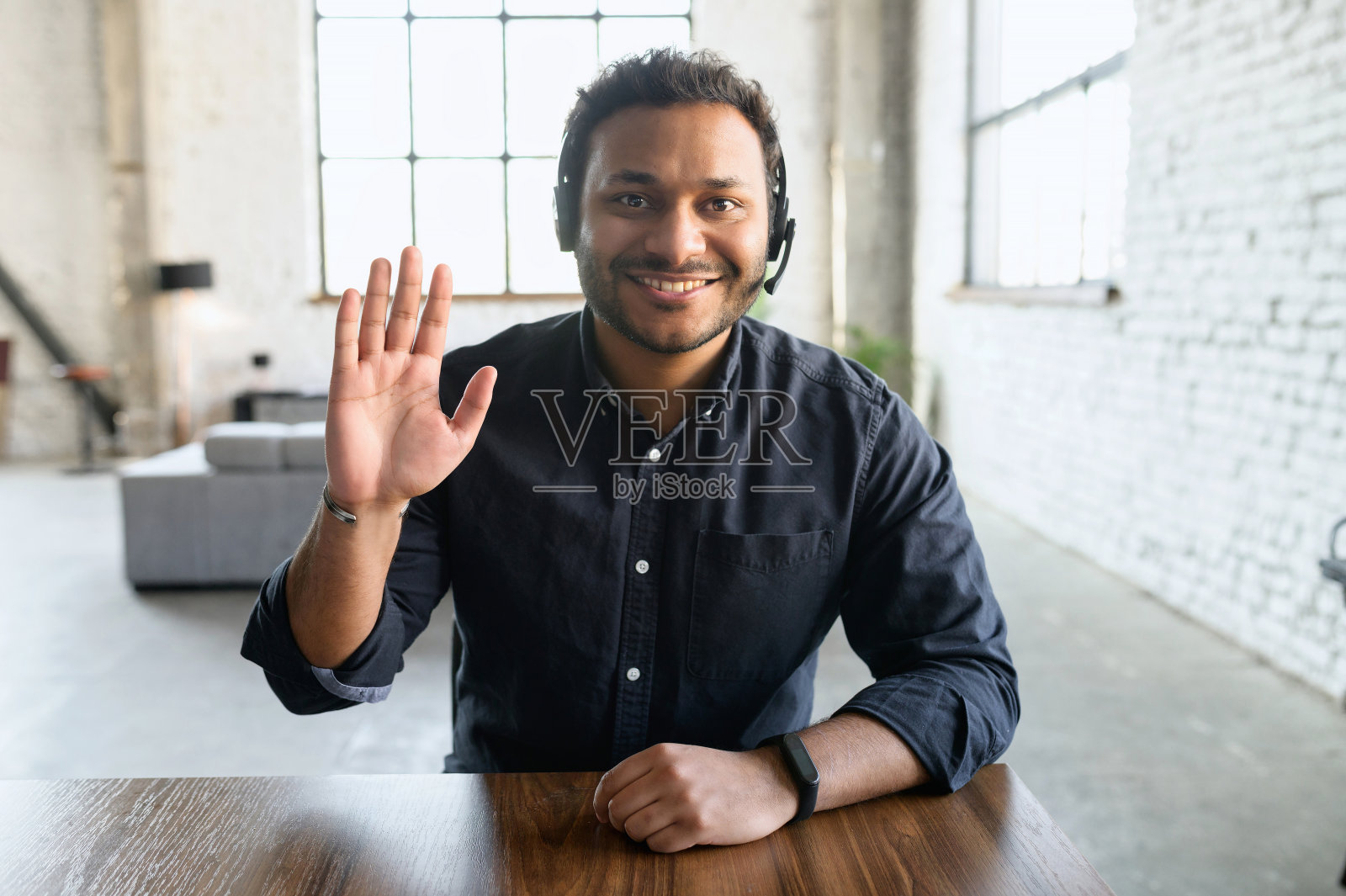 印度人在现代办公室里戴耳机照片摄影图片