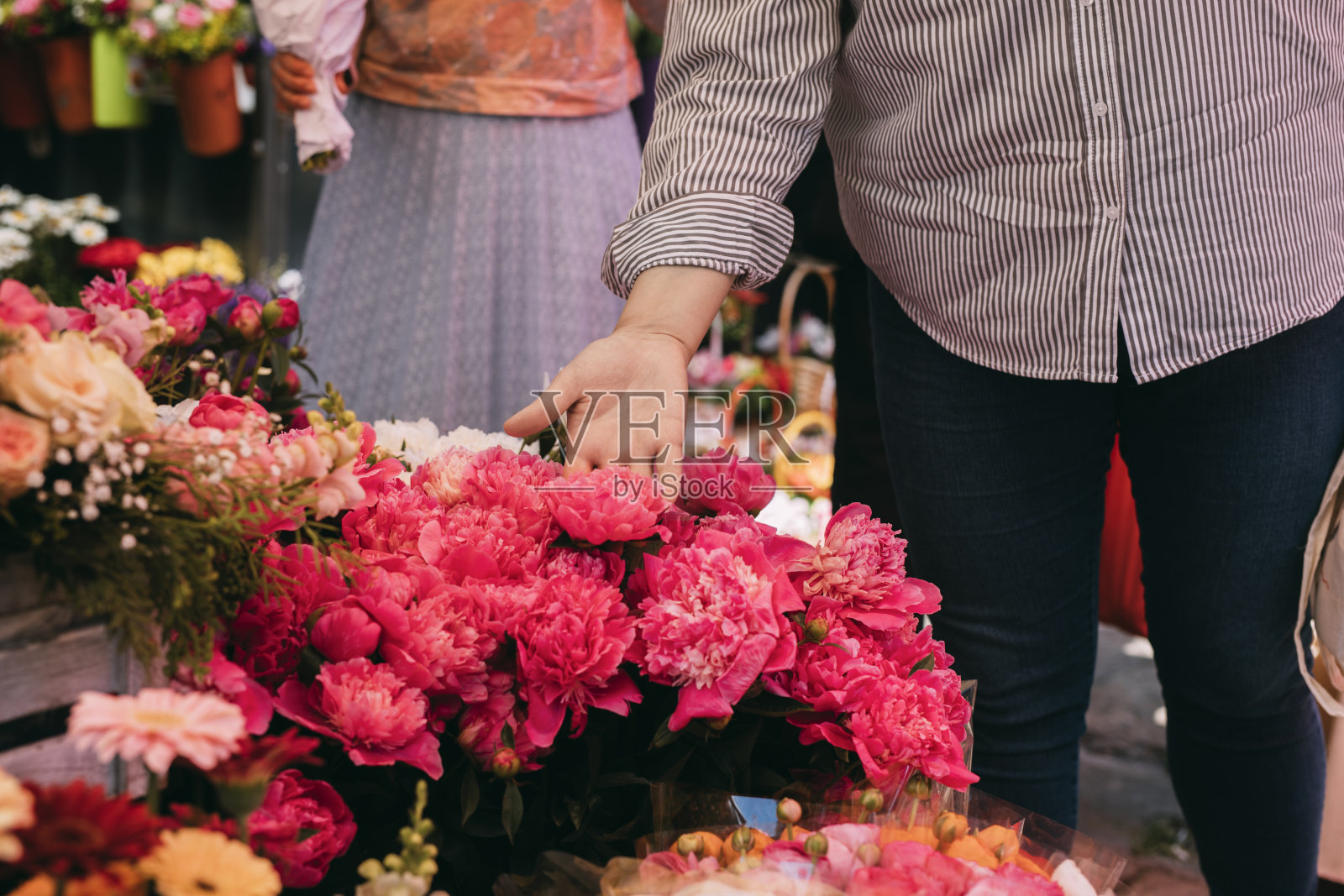 匿名大码女子在市场买花照片摄影图片