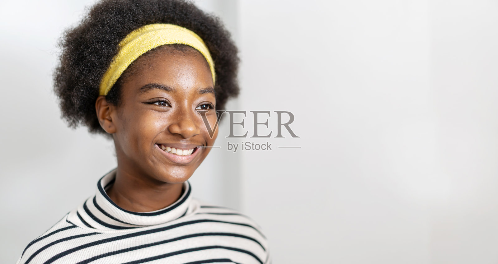 近侧侧视肖像微笑的年轻女子，非洲裔美国人，漂亮的，迷人的，可爱的，可爱的，开朗的，活泼的，卷曲的头发的女孩照片摄影图片