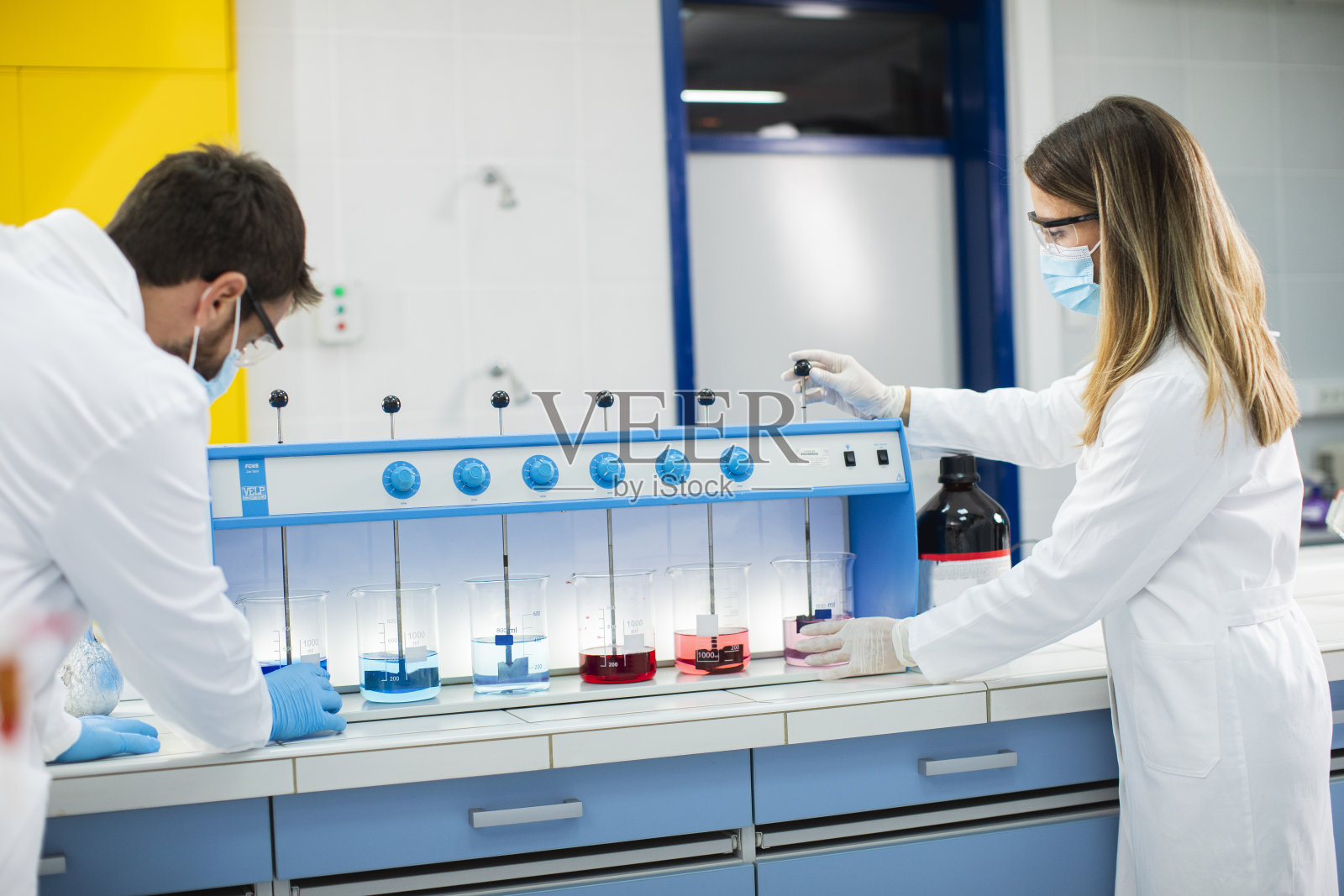 一群年轻的研究人员在实验室分析絮凝器中的化学数据照片摄影图片