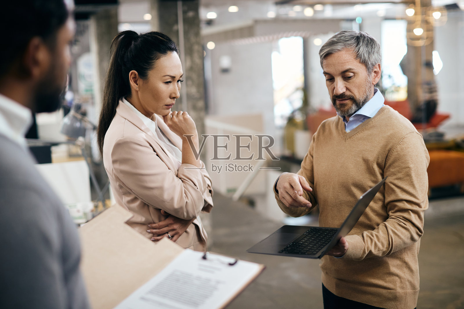 一位亚洲公司经理和她的业务团队在办公室的简报会上使用笔记本电脑。照片摄影图片