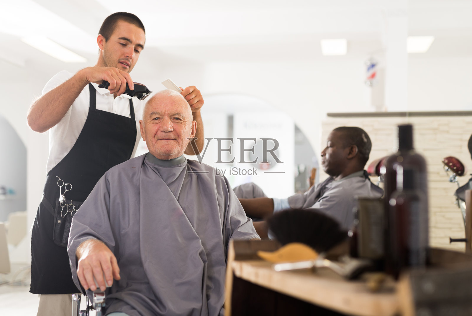 发型师为一位白发男子理发照片摄影图片