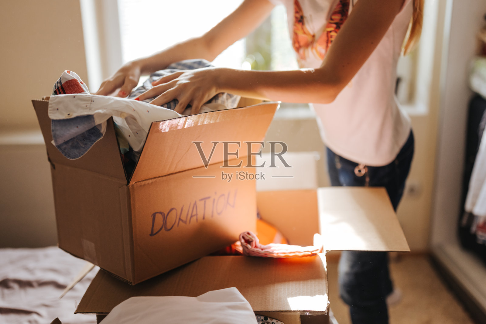 女孩在家里为捐赠准备衣服照片摄影图片
