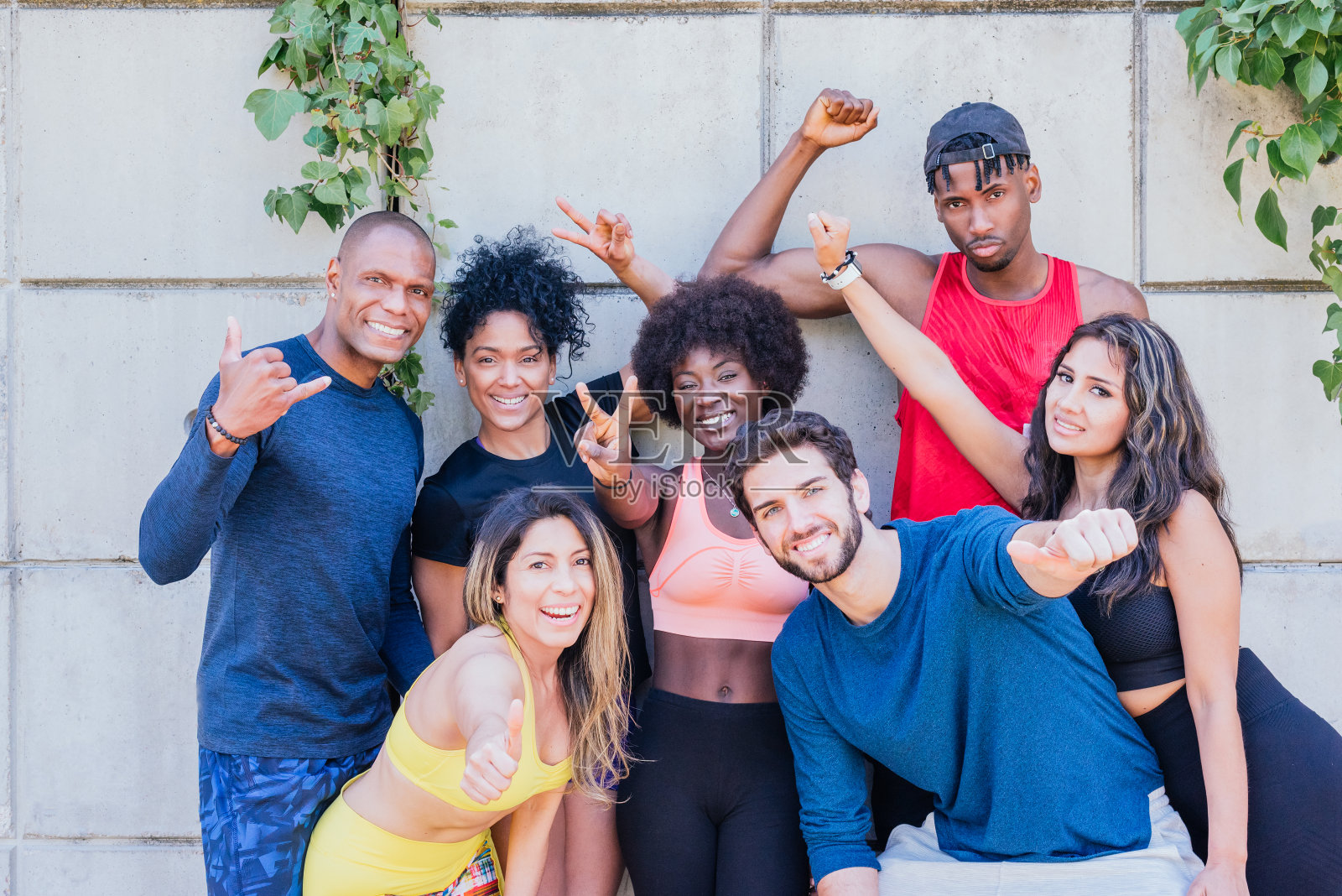 一组跑步者举起拳头对着镜头微笑的肖像。照片摄影图片