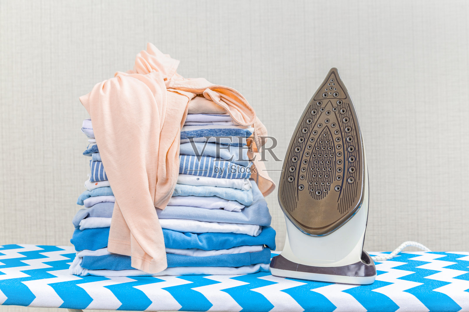 新式熨斗和干净衣服在船上室内。洗衣日照片摄影图片