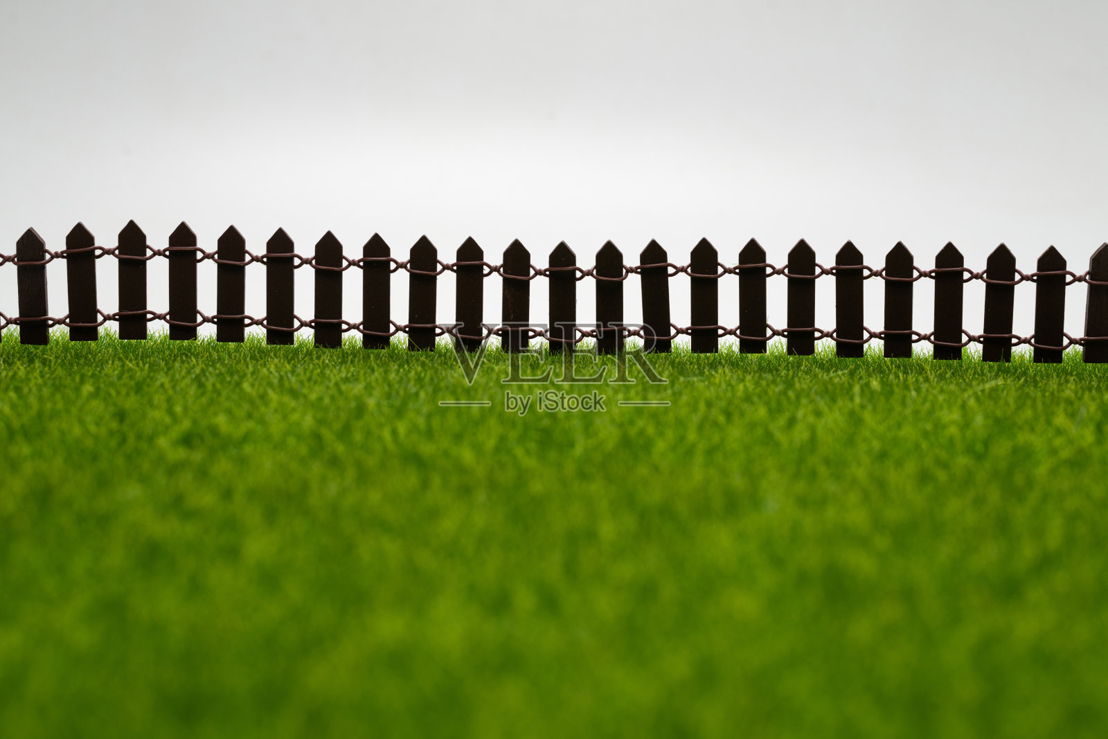 绿色的草和篱笆孤立在白色的背景。照片摄影图片