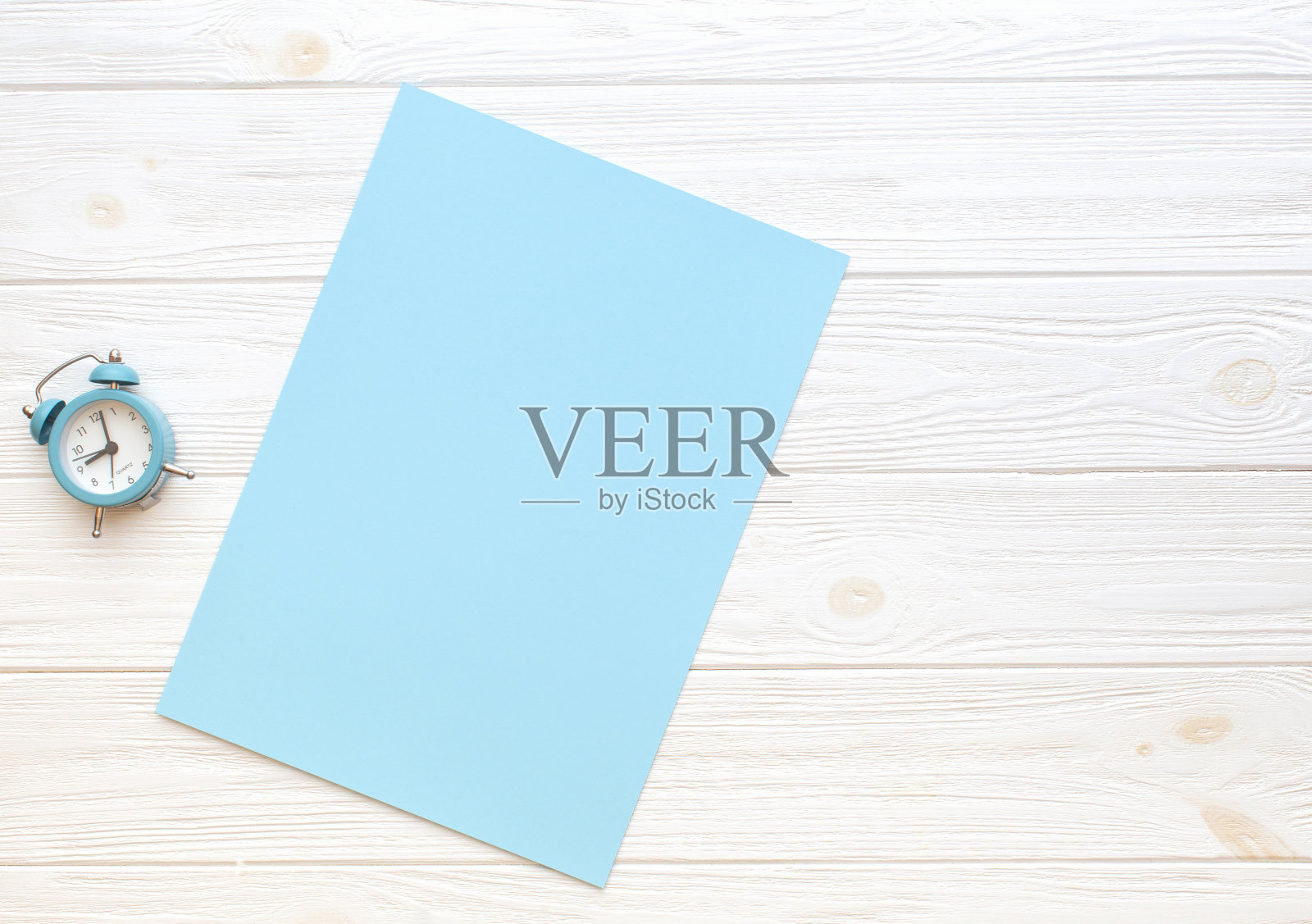 时钟和空白纸卡上的木制背景。复制空间，平铺，照片摄影图片