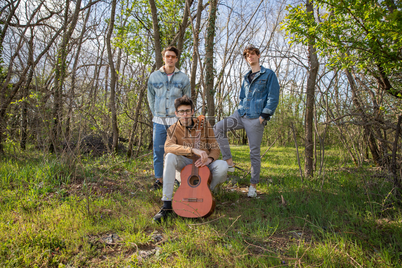 一群年轻艺术家在森林里摆姿势拍照。照片摄影图片