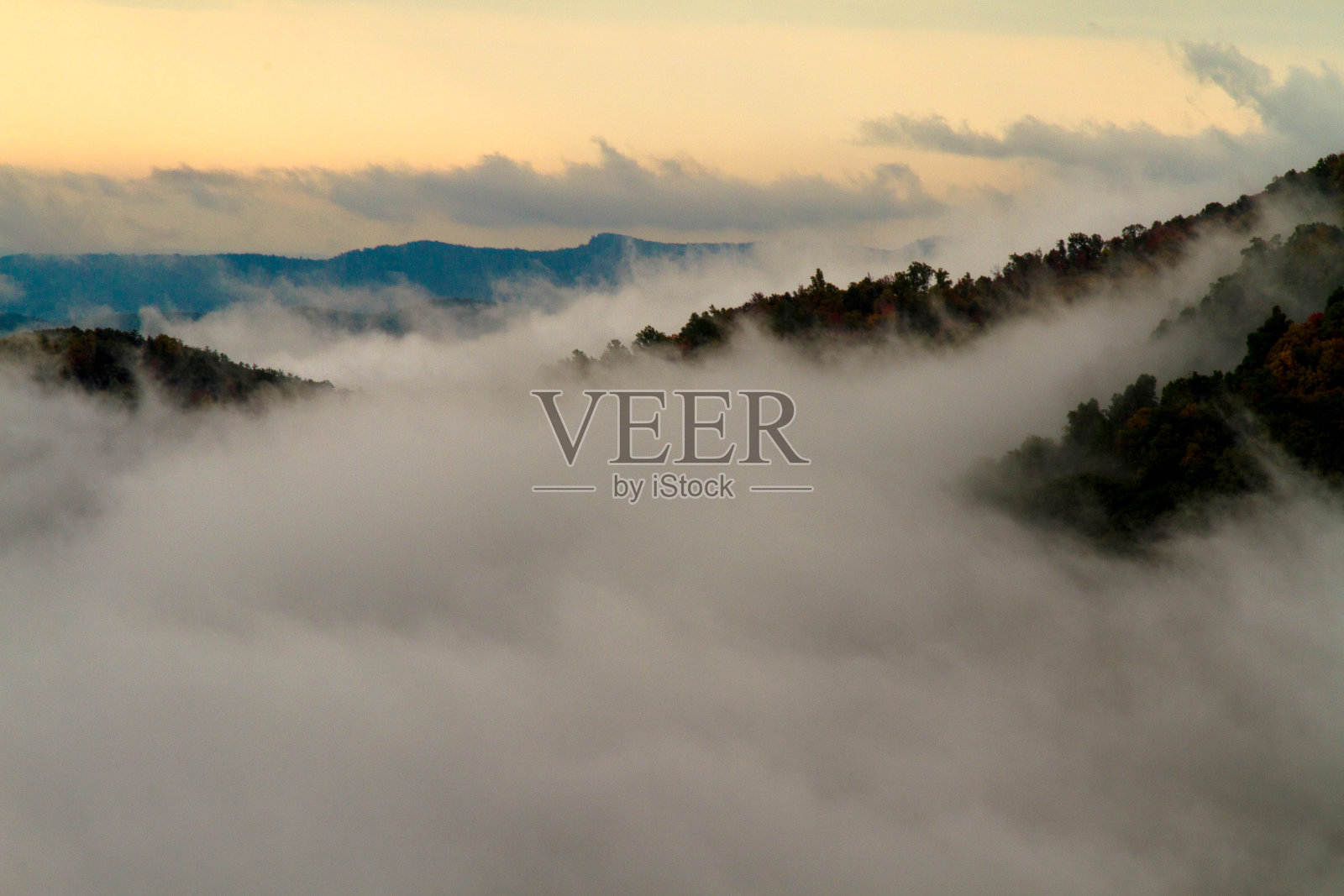 高角度的观点，雾和云在山上日落照片摄影图片