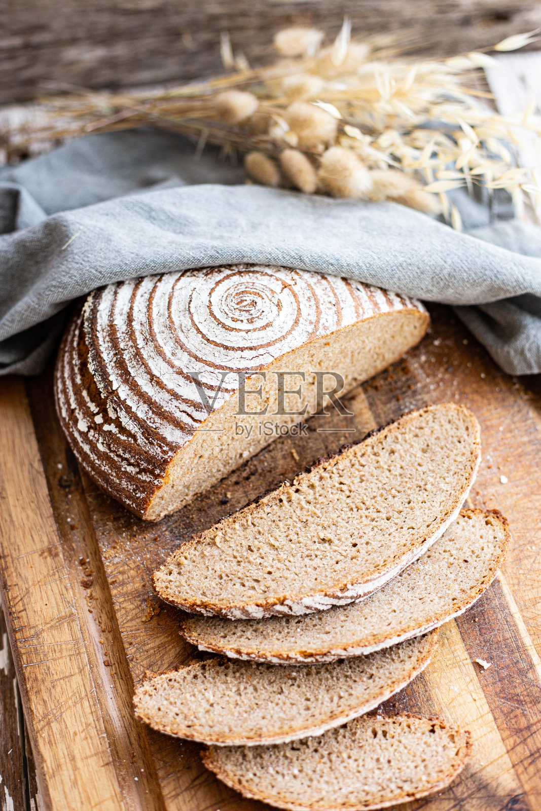 农家面包放在木砧板上，切成薄片躺在周围照片摄影图片