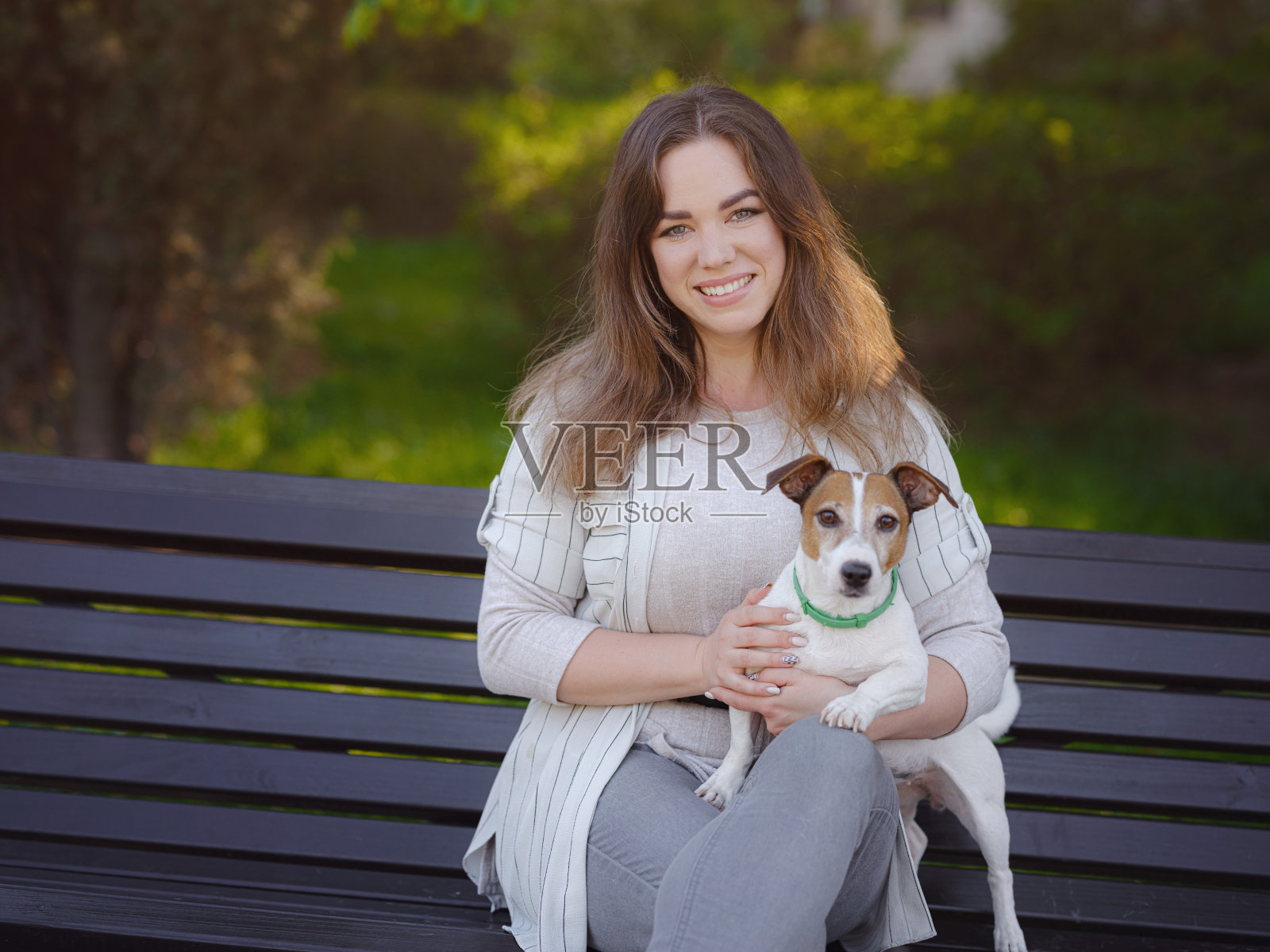 年轻女子和她可爱的杰克罗素梗在户外。照片摄影图片