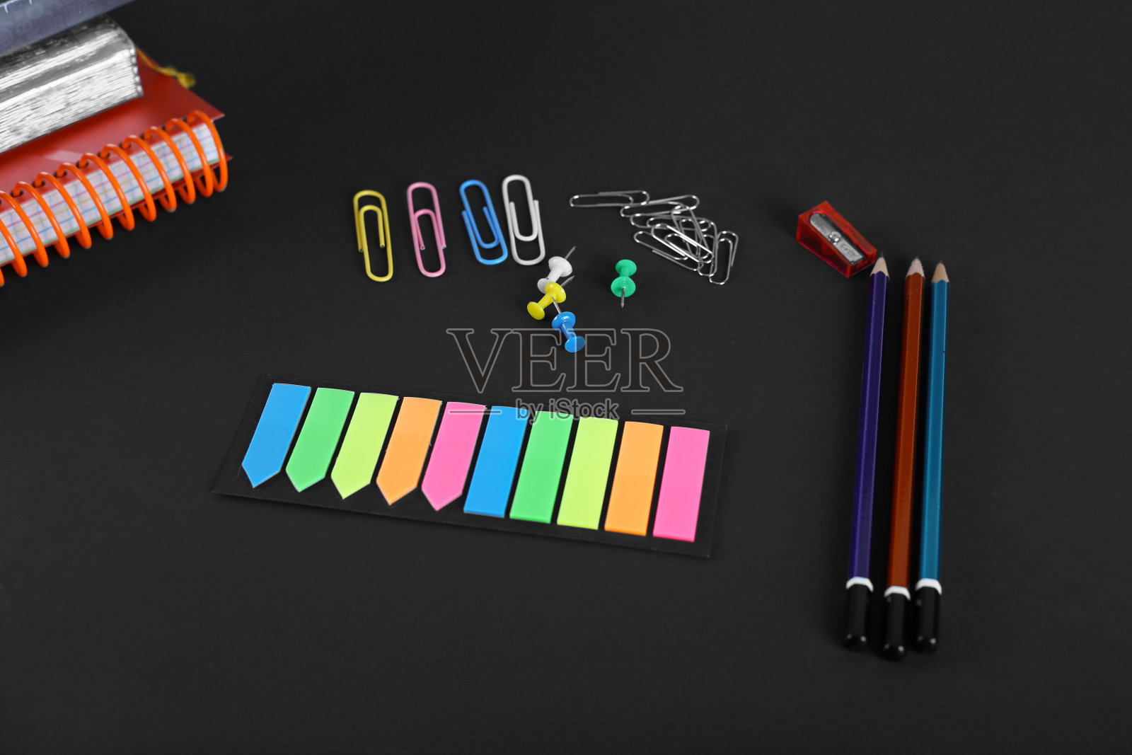 黑色背景上的办公用品。回形针、纽扣、记事本、铅笔。研究中,办公室照片摄影图片