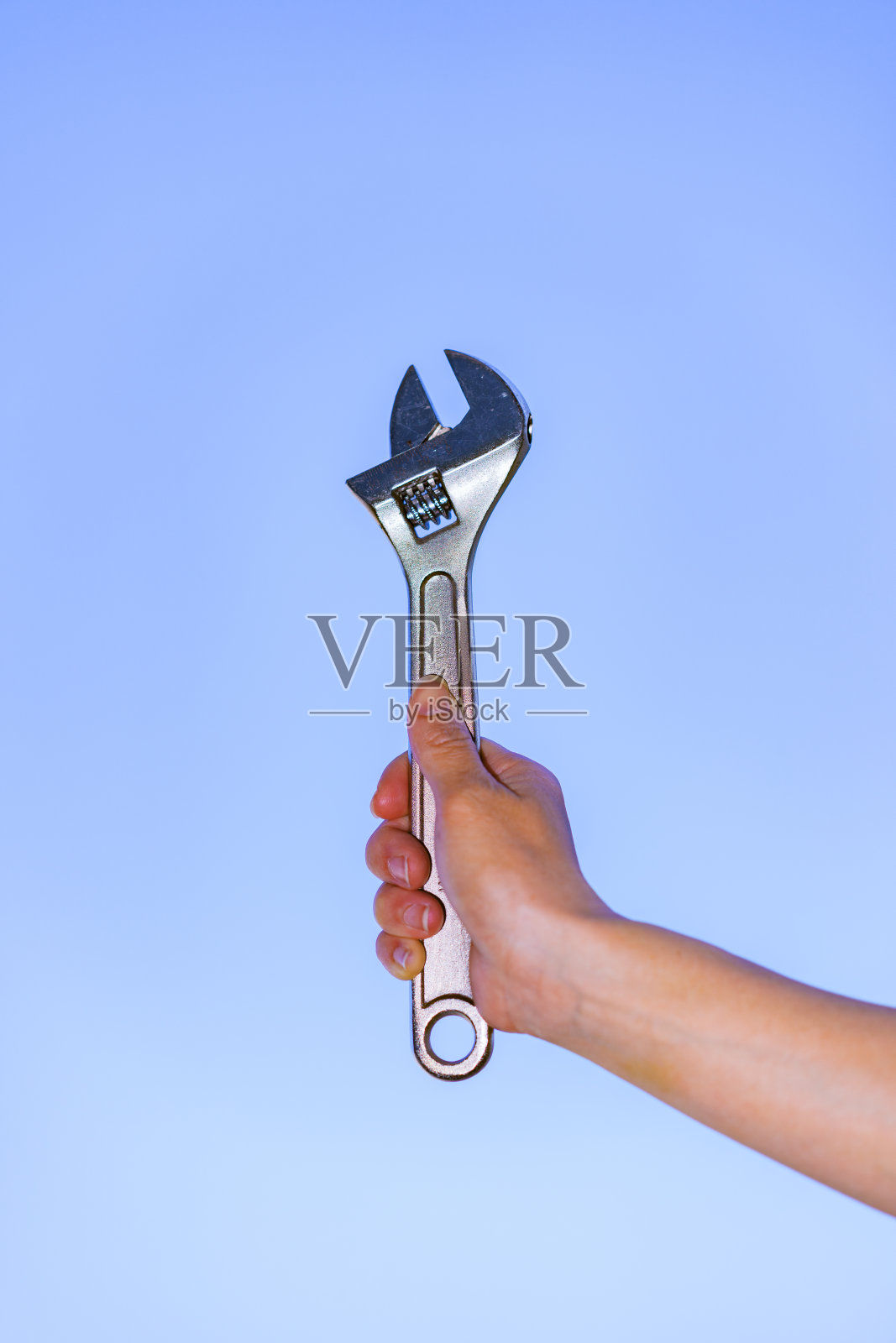 蓝天背景中的猴子扳手照片摄影图片