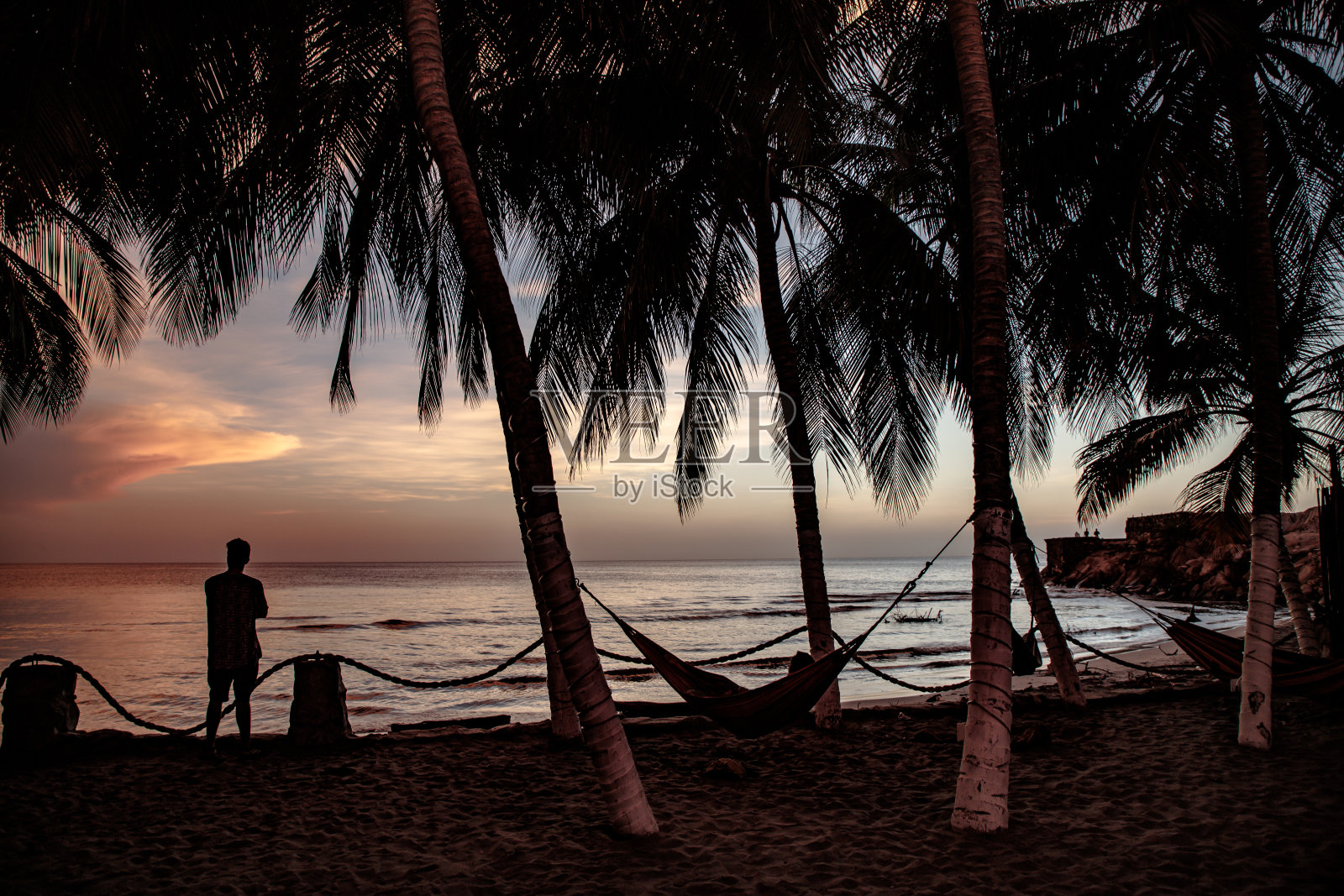 一个人在热带海滩上欣赏日落照片摄影图片