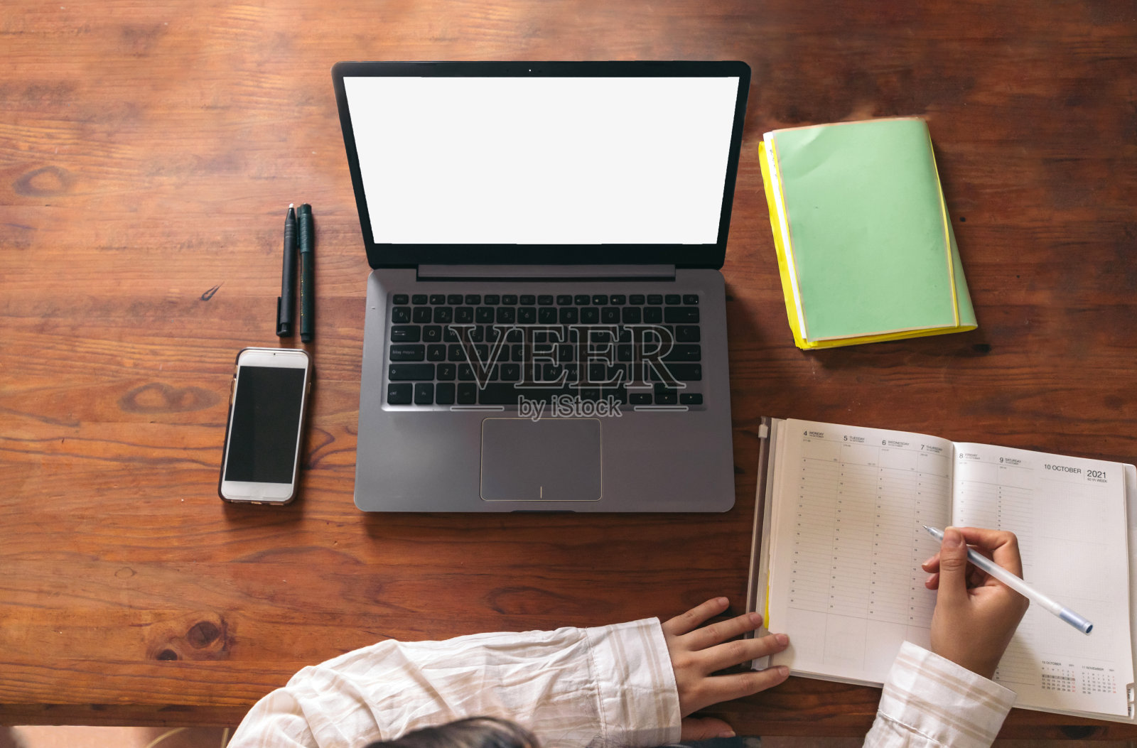 年轻妇女在家工作。笔记本电脑笔记本移动。俯视图照片摄影图片