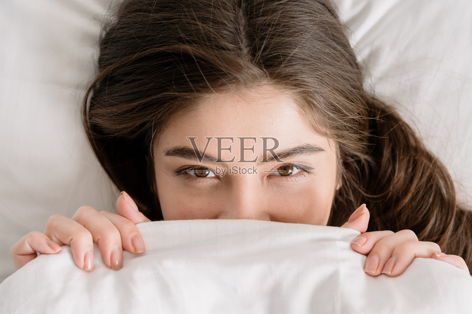 年轻女子用白毯子盖着脸照片摄影图片