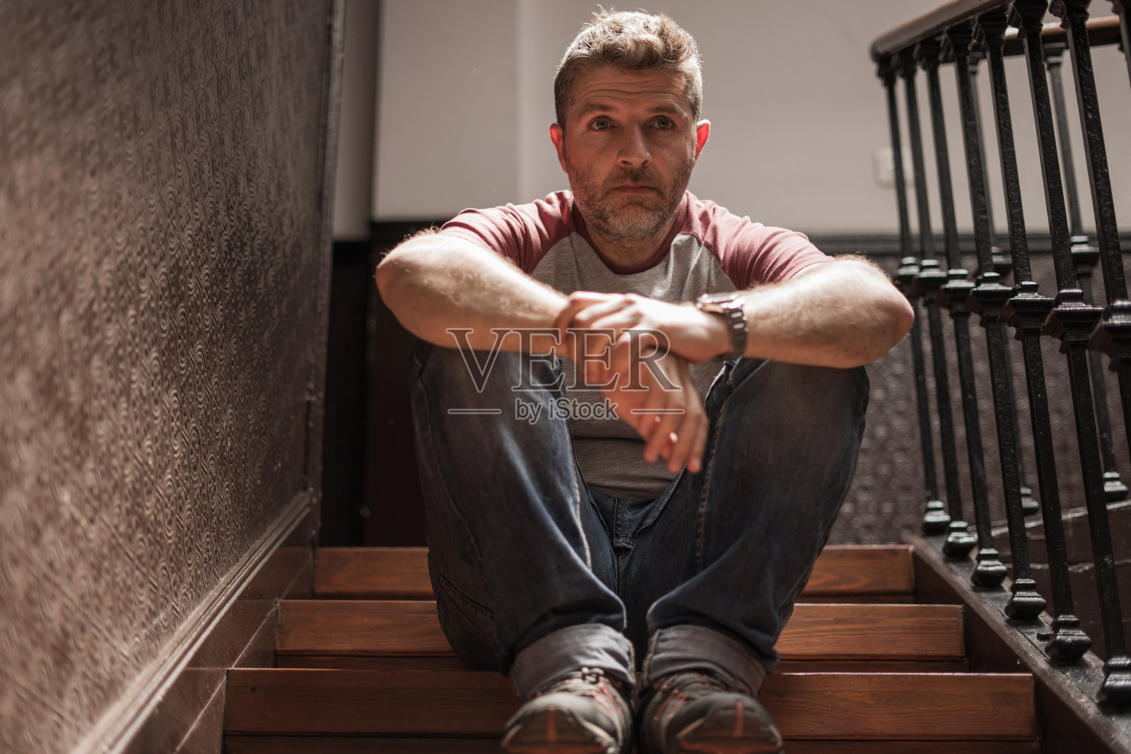 失业与离婚：中年男子坐在楼梯上，忧心忡忡，遭受抑郁问题照片摄影图片