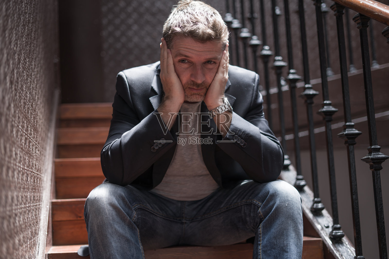 失业与离婚：中年男子坐在楼梯上，忧心忡忡，遭受抑郁问题照片摄影图片