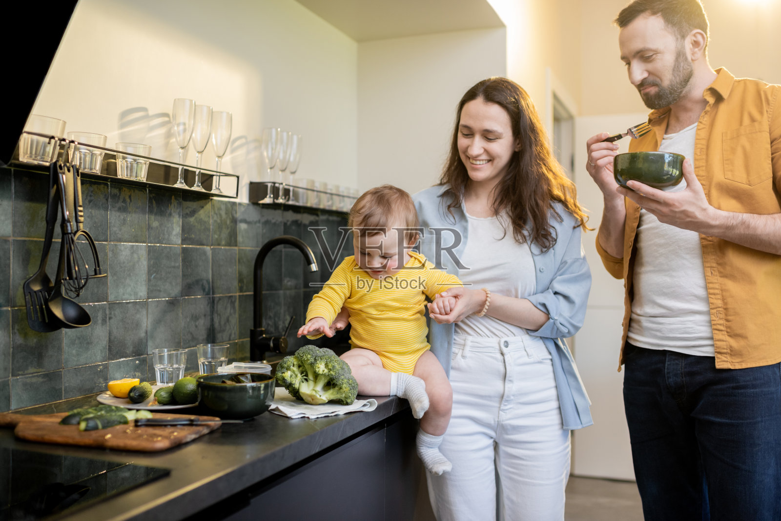 厨房里有个婴儿的一家人照片摄影图片