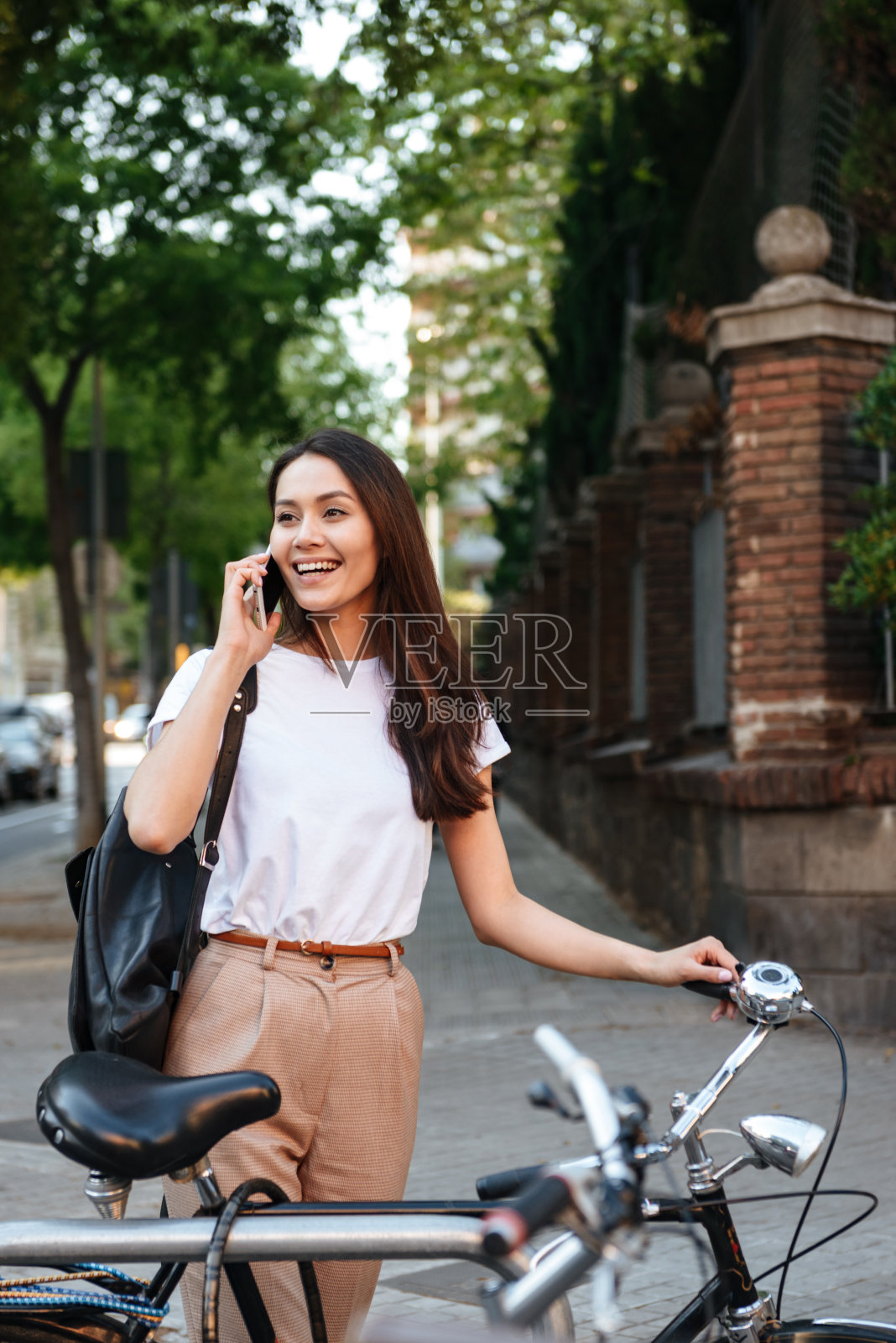 神奇的微笑美丽的女人用手机说话。照片摄影图片