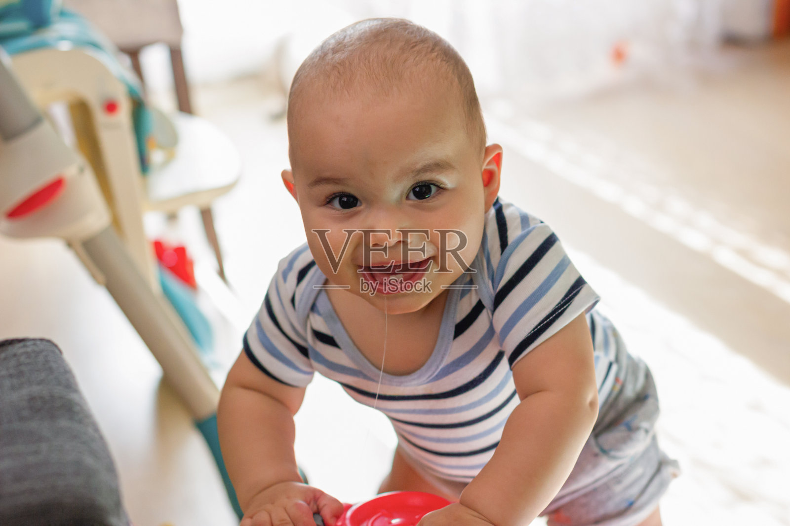 快乐微笑的小男孩玩玩具。娃娃脸特写照片摄影图片