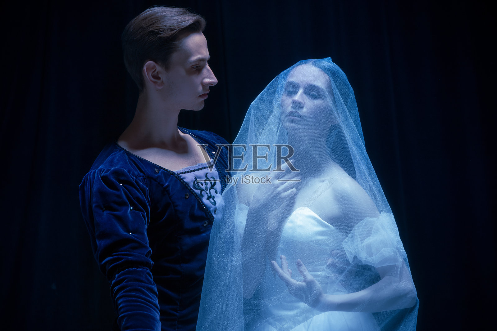 艺术表现。两个优雅的芭蕾舞者，男人和女人在黑暗的背景下跳舞。照片摄影图片