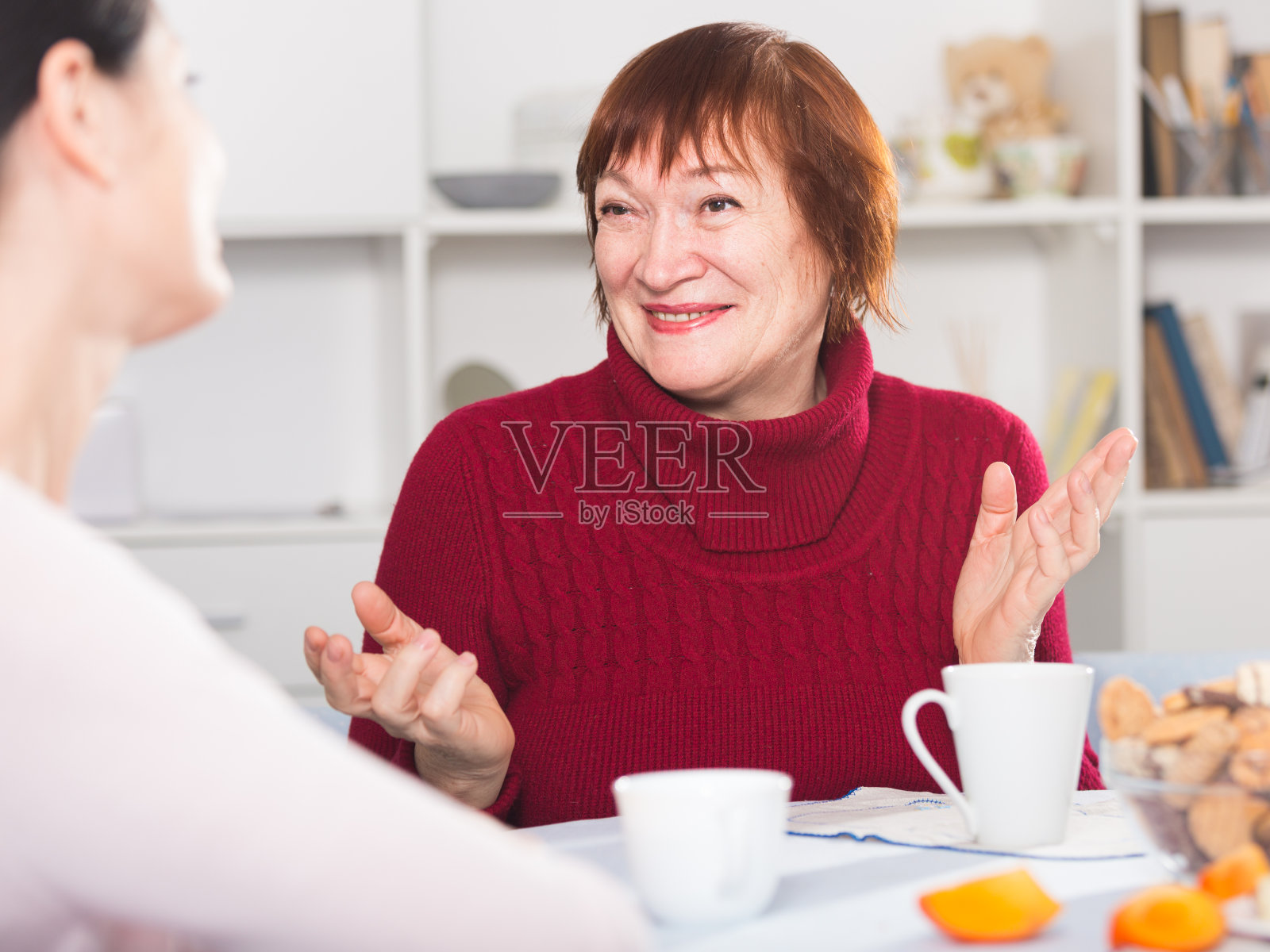 成年女性和女儿边喝咖啡边聊天照片摄影图片
